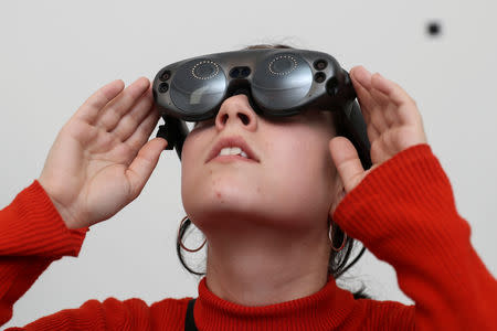 An attendee looks through augmented reality glasses at Marina Abramovic's exhibition 'The Life', the world's first large-scale performance exhibited using Mixed Reality at the Serpentine Gallery in London, Britain February 18, 2019. REUTERS/Simon Dawson