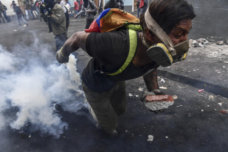 A demonstrator clashes with riot police as thousands march against Ecuadorean President Lenin Moreno's decision to slash fuel subsidies, in Quito on Oct. 9, 2019. (Photo: Martin Bernetti/AFP via Getty Images)