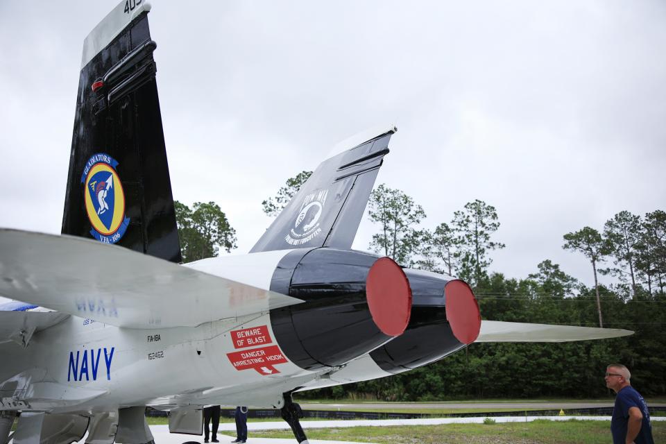 Daniel "Dano" Mastrolia looks at the rear of an F/A-18 Hornet fighter jet he helped restore at the National POW/MIA Memorial & Museum at the former Cecil Field in Jacksonville.