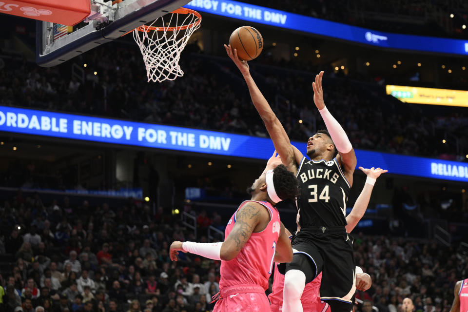 Milwaukee Bucks forward Giannis Antetokounmpo (34) goes to the basket against Washington Wizards guard Jordan Goodwin (7) during the first half of an NBA basketball game, Sunday, March 5, 2023, in Washington. Wizards center Daniel Gafford was called for a foul on the play. (AP Photo/Nick Wass)