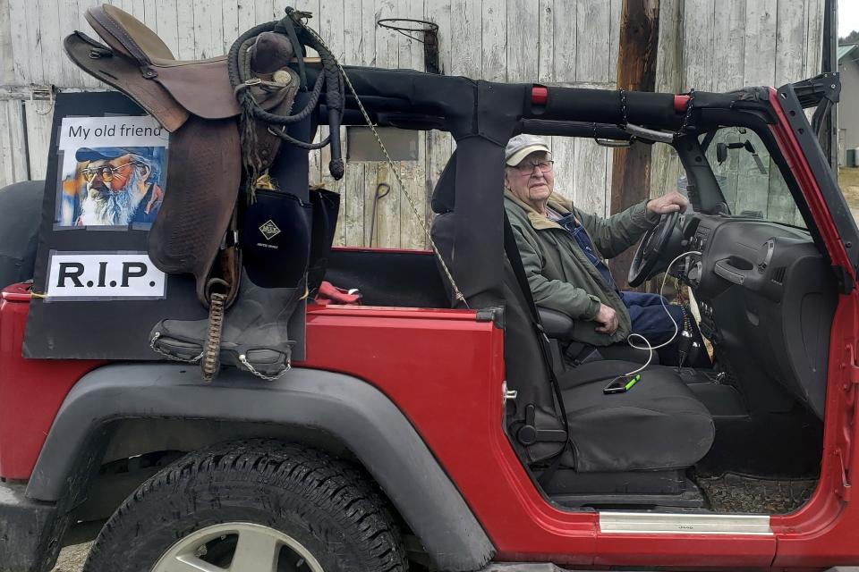 In this April 5, 2020, photo provided by Jill Adams, her father, Bill Adams, prepares to ride in a procession in Wilmington, Vt., to pay respects to his late friend Cleon Boyd, who died on April 3 from COVID-19. Less than a week later Cleon's twin brother, Leon Boyd, also died from the coronavirus. (Jill Adams via AP)