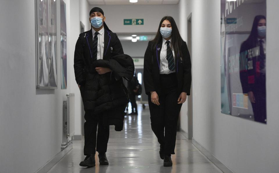 Children wearing face masks walking down a corridor at Hounslow Kingsley Academy in West London in March - Kirsty O'Connor/PA