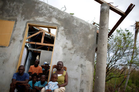 Matha Dominique (R), 67, poses for a photograph with her relatives at their destroyed house after Hurricane Matthew hit Jeremie, Haiti, October 19, 2016. "I thought that it was the end of the world. I lost everything, my crops, my animals - things that took many years to build, disappeared in few minutes. At my age, do you think that I could do something or start again, I think not. God is accountable for my situation, should I thank him for having done this to me?" said Dominique. REUTERS/Carlos Garcia Rawlins