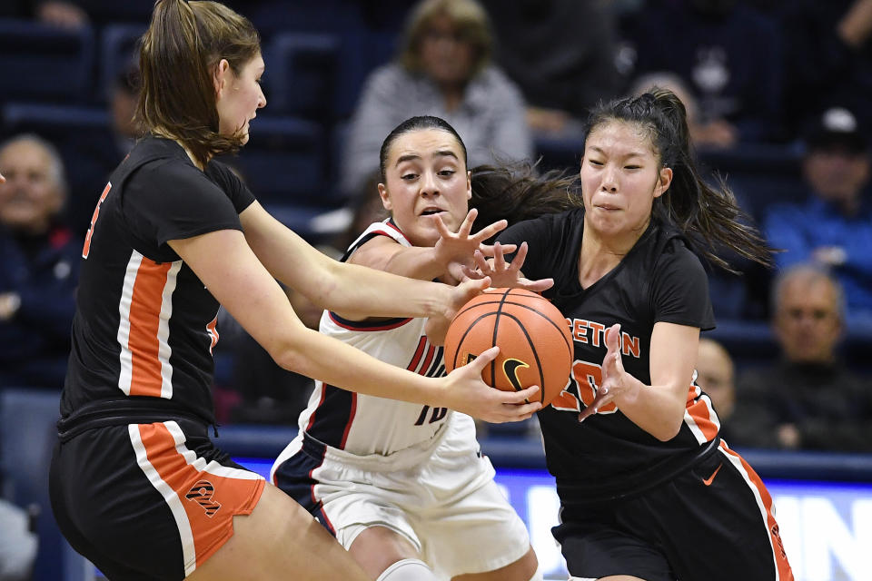 Connecticut's Nika Muhl, center, attempts to intercept a pass between Princeton's Paige Morton, left, and Kaitlyn Chen during the first half of an NCAA college basketball game Thursday, Dec. 8, 2022, in Storrs, Conn. (AP Photo/Jessica Hill)