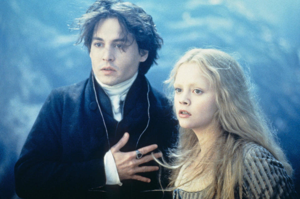 Johnny Depp and Christina Ricci stand beside each other in a misty forest