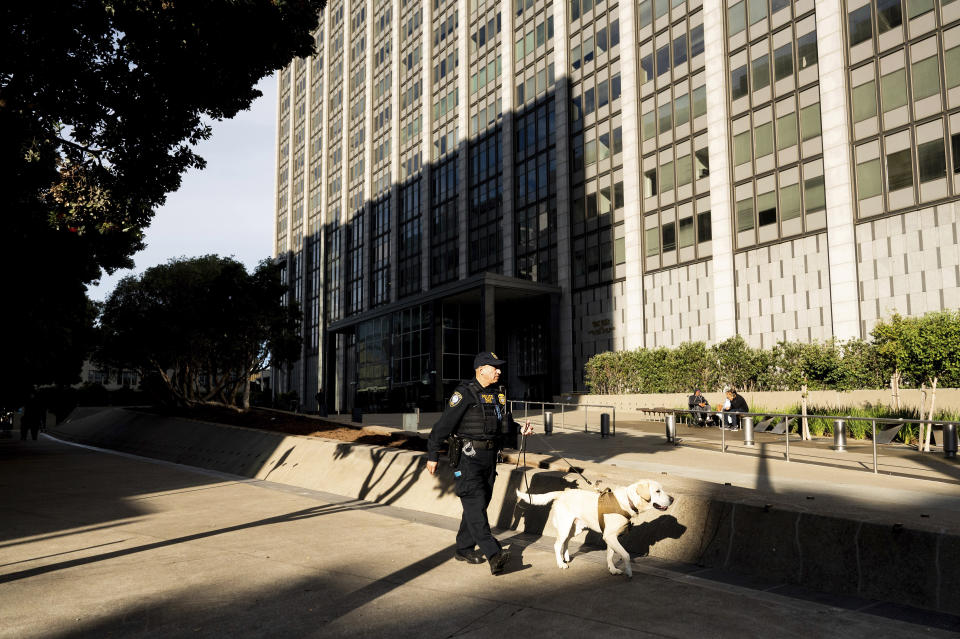 A Department of Homeland Security officer walks the perimeter of the Phillip Burton Federal Building and U.S. Courthouse where the federal trial of David DePape is underway in San Francisco, on Monday, Nov. 13, 2023. Prosecutors say DePape broke into former House Speaker Nancy Pelosi's home and bludgeoned her husband Paul Pelosi with a hammer in October 2022. (AP Photo/Noah Berger)