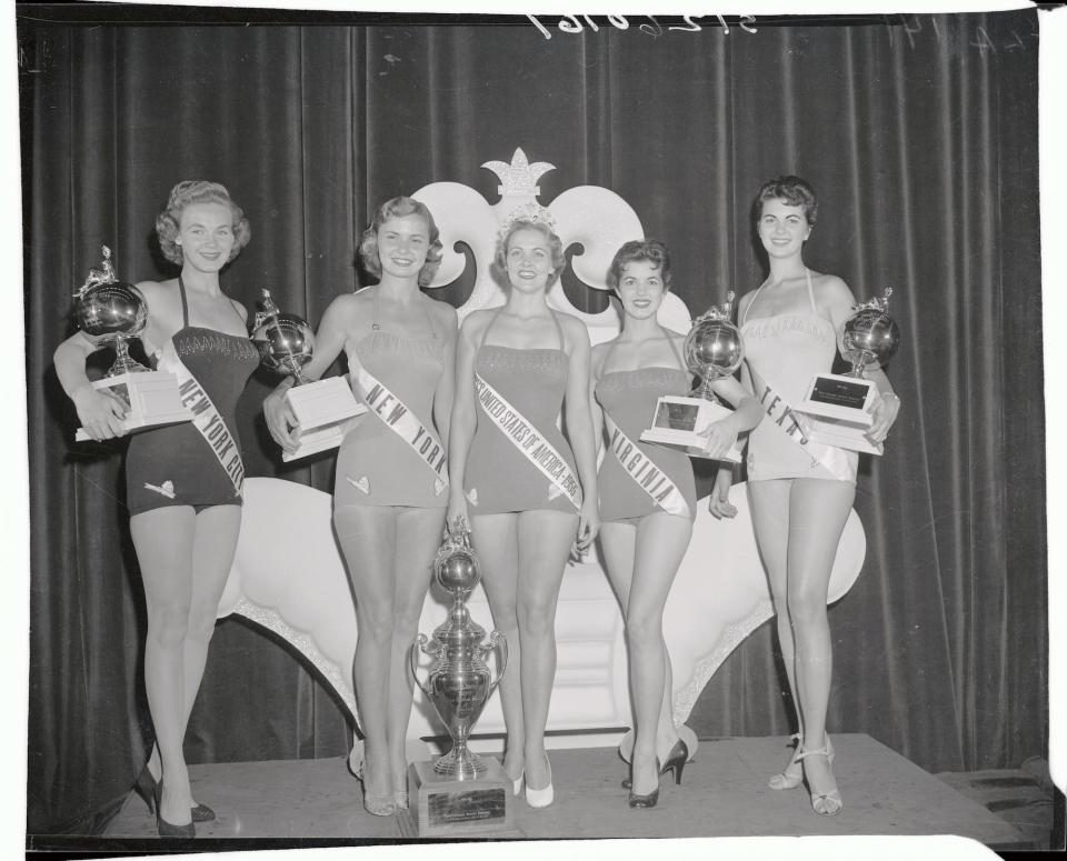 Miss USA 1954 Mirian Stevenson poses between other pageant contestants.