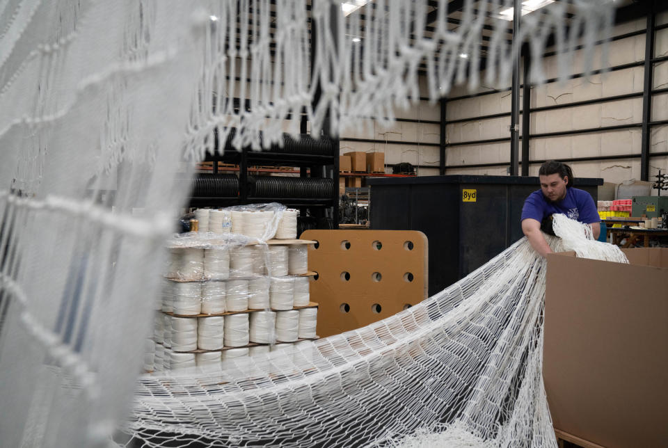 Alyssa Latham stacks netting, March 9, 2022, at West Coast Netting in the Kingman Industrial Park, 5075 Flightline Drive, Kingman, Ariz.