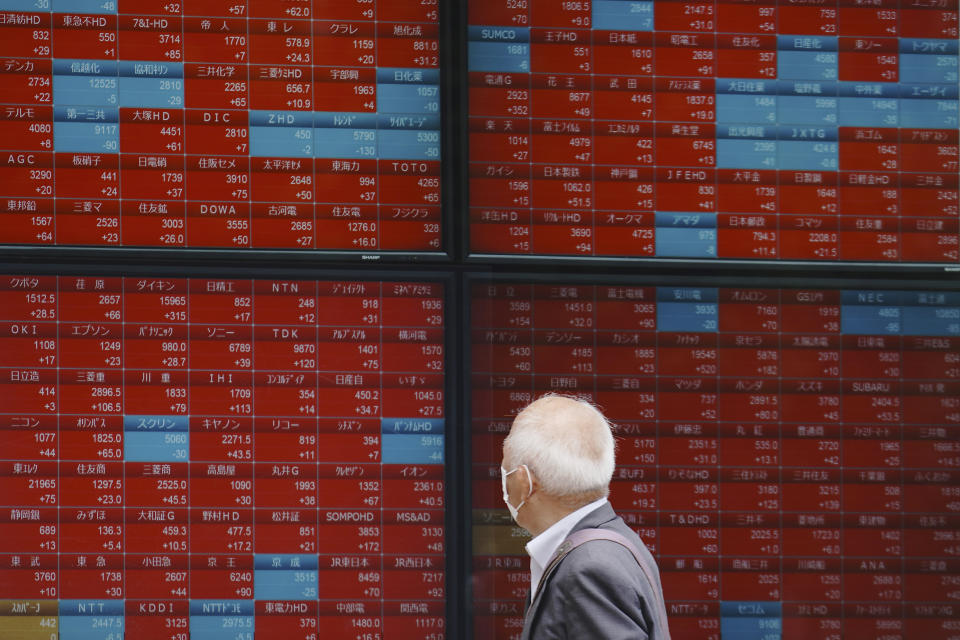 A man looks at an electronic stock board showing Japan's Nikkei 225 index at a securities firm in Tokyo Thursday, May 28, 2020. Asian stocks are mixed after an upbeat open, as hopes for an economic rebound from the coronavirus crisis were dimmed by tensions between the U.S. and China over Hong Kong and other issues. (AP Photo/Eugene Hoshiko)