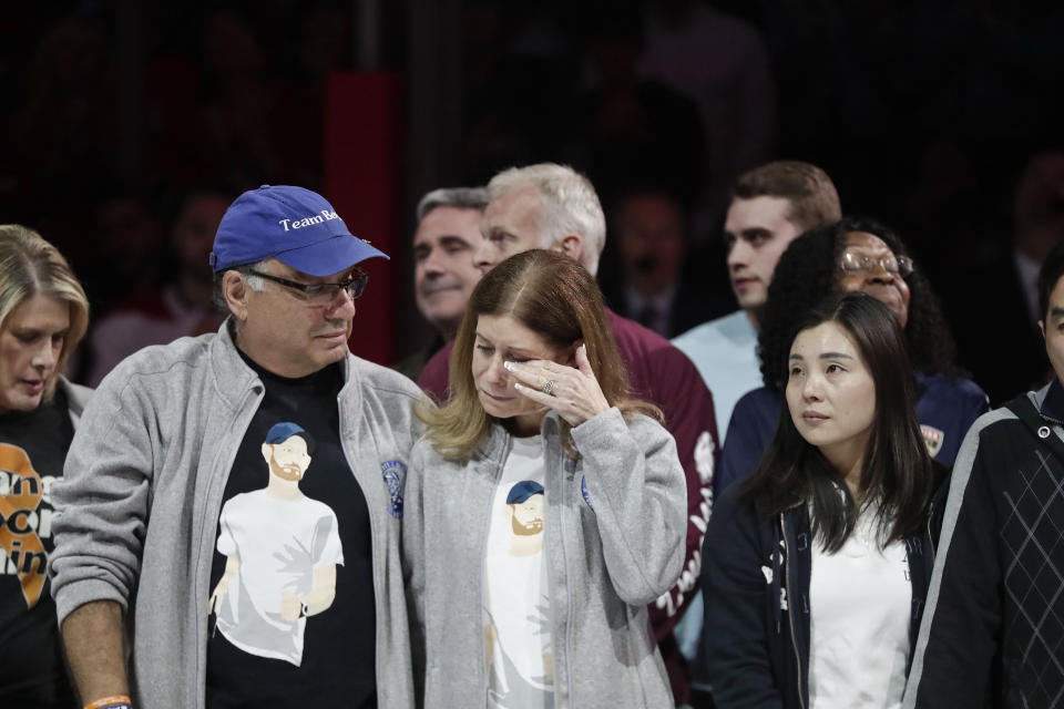 FILE - In this Feb. 17, 2019, file photo, Linda Beigel Schulman, right, wipes a tear from her eye as she stands with her husband, Michael Schulman, in honor of the survivors of the mass shooting at Marjory Stoneman Douglas High School in Florida. Michael Schulman, the father of shooting victim Scott Beigel, wrote a newspaper opinion piece in which he said it would be better for everyone if the defendant, Nikolas Cruz, could plead guilty and be locked away for life. (AP Photo/Brynn Anderson, File)