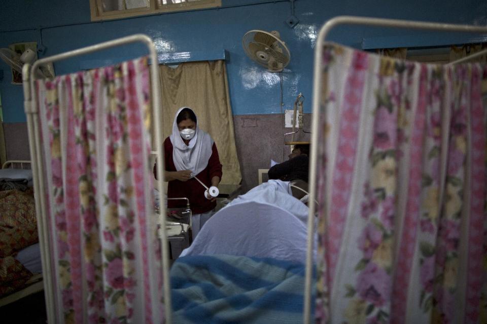 In this Sunday, Feb. 16, 2014, photo, nurse Rakhal, cleans the wounds of Pakistani patient, Zahid Rehmat, 33, who was shot by criminals while trying to rob him, at the male wards of St. Joseph’s Hospice, in Rawalpindi, Pakistan. Mohammed Aqeel spent weeks at home in Pakistan waiting for death after suffering a debilitating spinal cord injury in a car crash before friends suggested he come to St. Joseph’s Hospice on the outskirts of the capital, Islamabad. Now 13 years later, his life and those of some 40 others who live on its grounds might be changed forever as this hospital of last resort faces closure over its rising debts. (AP Photo/Muhammed Muheisen)