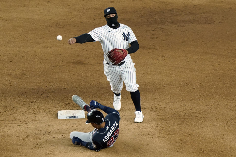 New York Yankees second baseman Rougned Odor throws to first after forcing out Atlanta Braves' Ehire Adrianza on a ball hit by Marcell Ozuna, who was safe during the ninth inning of a baseball game Wednesday, April 21, 2021, at Yankee Stadium in New York. The Braves won 4-1. (AP Photo/Kathy Willens)