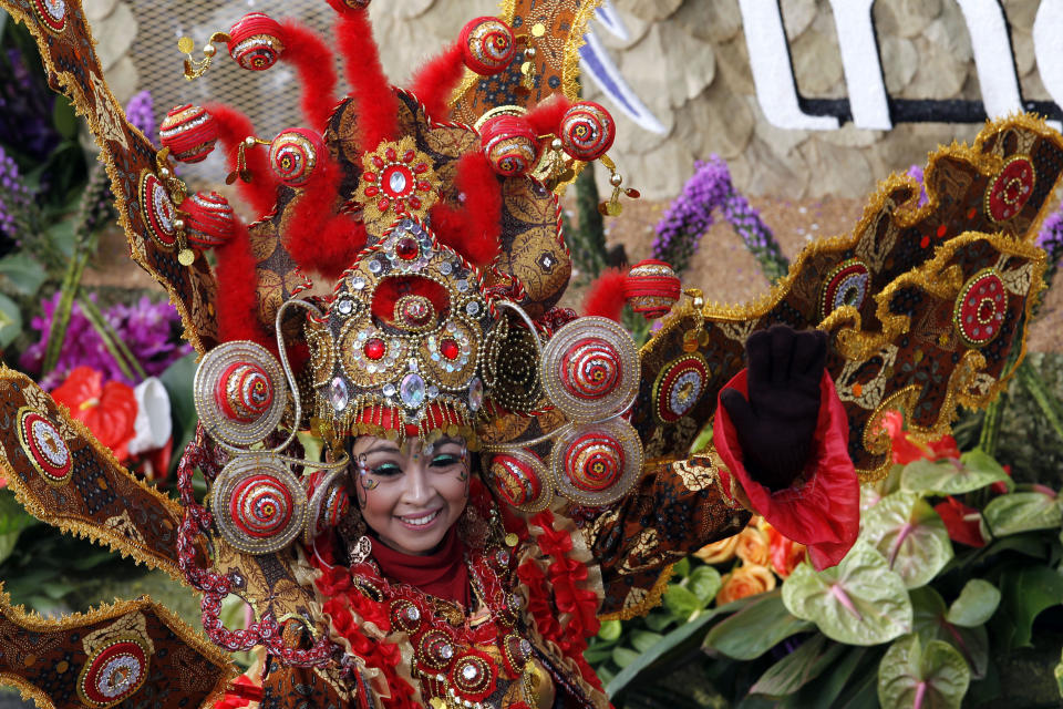 A woman smiles from the float "Wonderful Indonesia" from the Ministry of Tourism and Creative Economies, Republic of Indonesia_the winner of the Presidents trophy for the most innovative use and presentation of flowers_ in the 124th Rose Parade in Pasadena, Calif., Tuesday, Jan. 1, 2013. (AP Photo/Patrick T. Fallon)