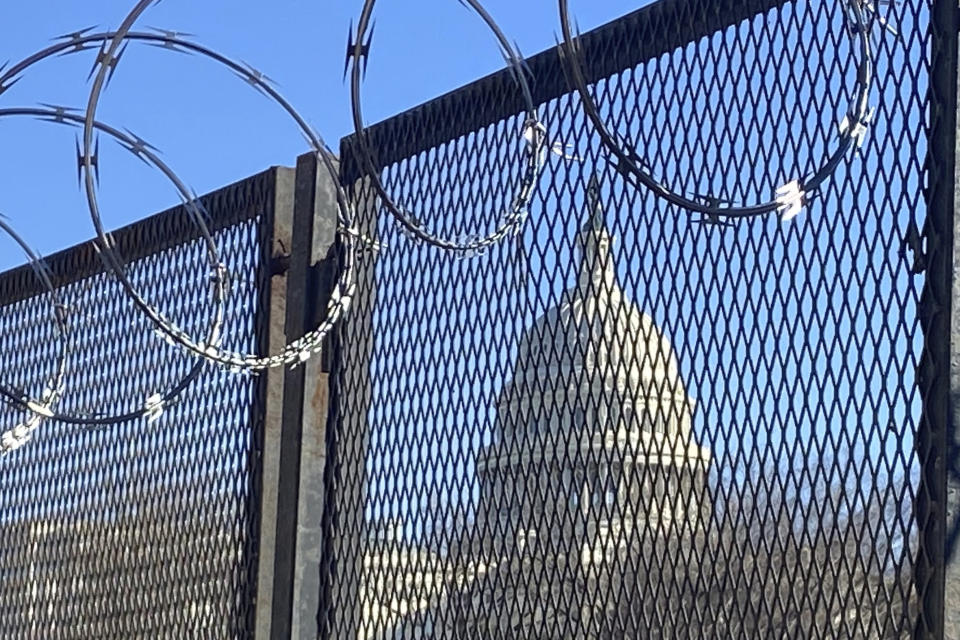 In this Saturday, Jan. 23, 2021 photo, riot fencing and razor wire reinforce the security zone on Capitol Hill in Washington. (AP Photo/Eileen Putman)
