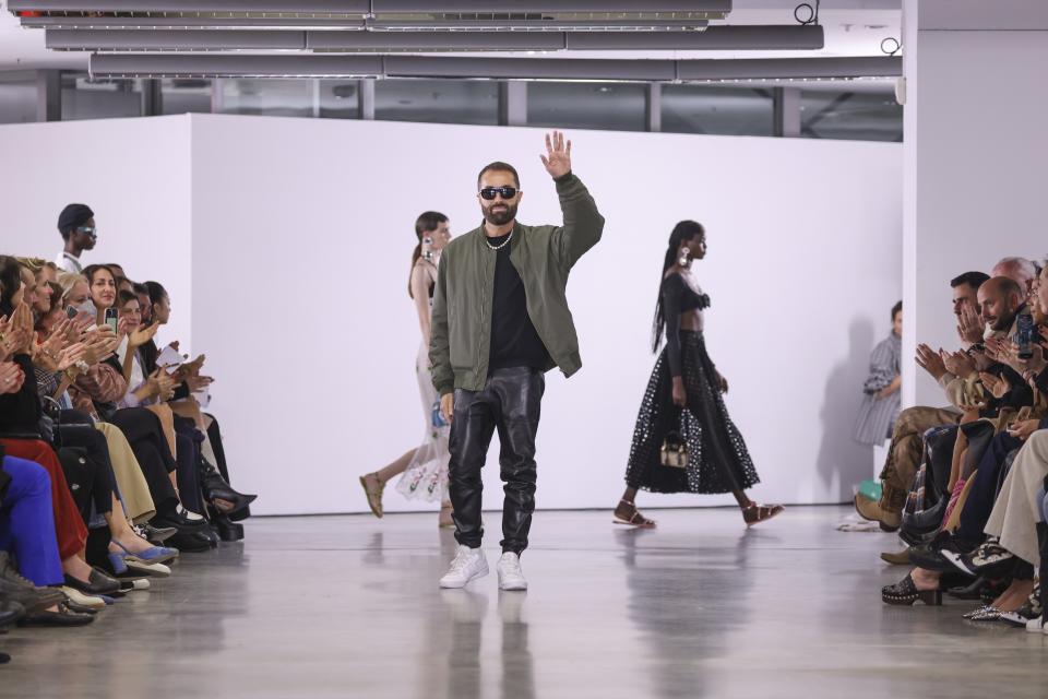 Designer Giambattista Valli accepts applause after the ready-to-wear Spring/Summer 2023 fashion collection presented Friday, Sept. 30, 2022 in Paris. (Photo by Vianney Le Caer/Invision/AP)