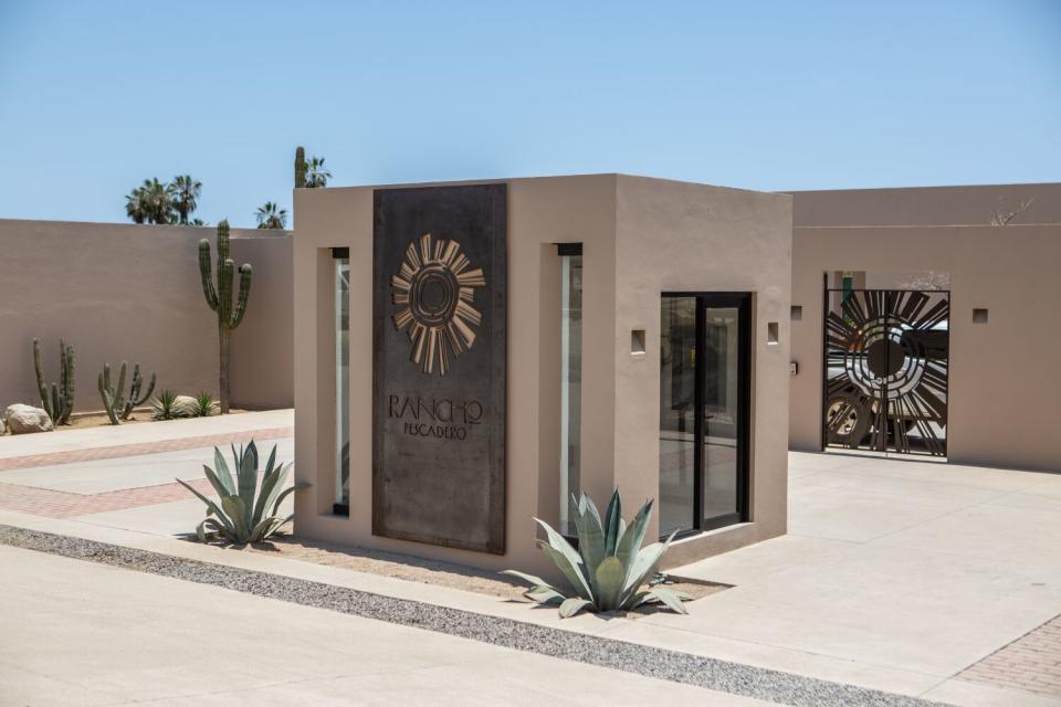 Agave plants and cactuses dot a walled courtyard.