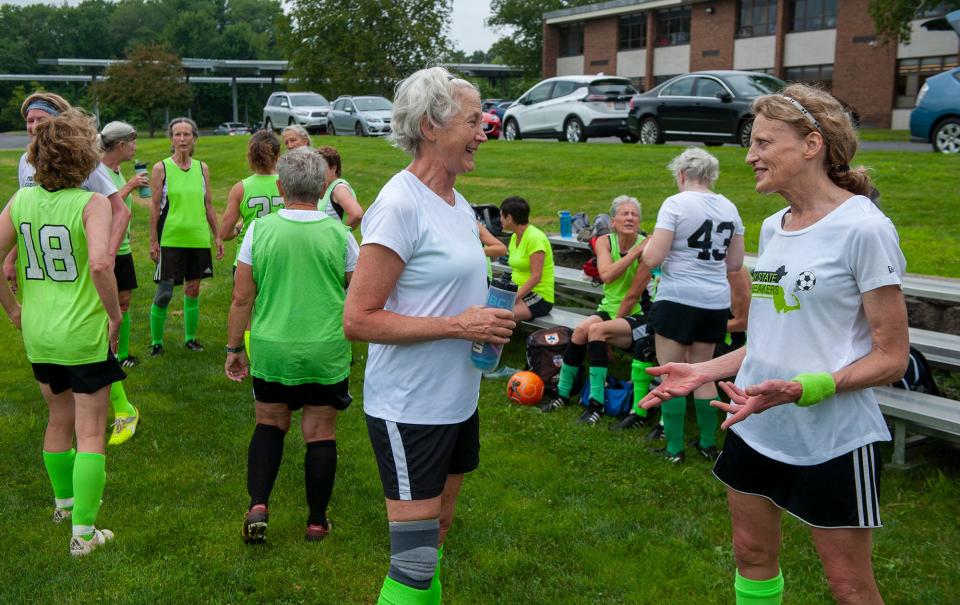 Mimi O'Donoghue, of Roslindale, left, and Sue Zimmermann, of Lexington, chat during a break at a Bay State Breakers practice for the over 50 and over 70 teams at the Brophy School in Framingham, July 21, 2023. 