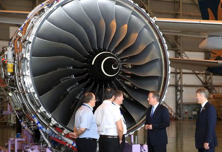 Britain's Prime Minister David Cameron (2nd R) talks with engineers next to Rolls-Royce's President of Aerospace Tony Wood (R) in front of a Rolls-Royce engine at a hangar in Noi Bai airport, in Hanoi, July 29, 2015. REUTERS/Stringer