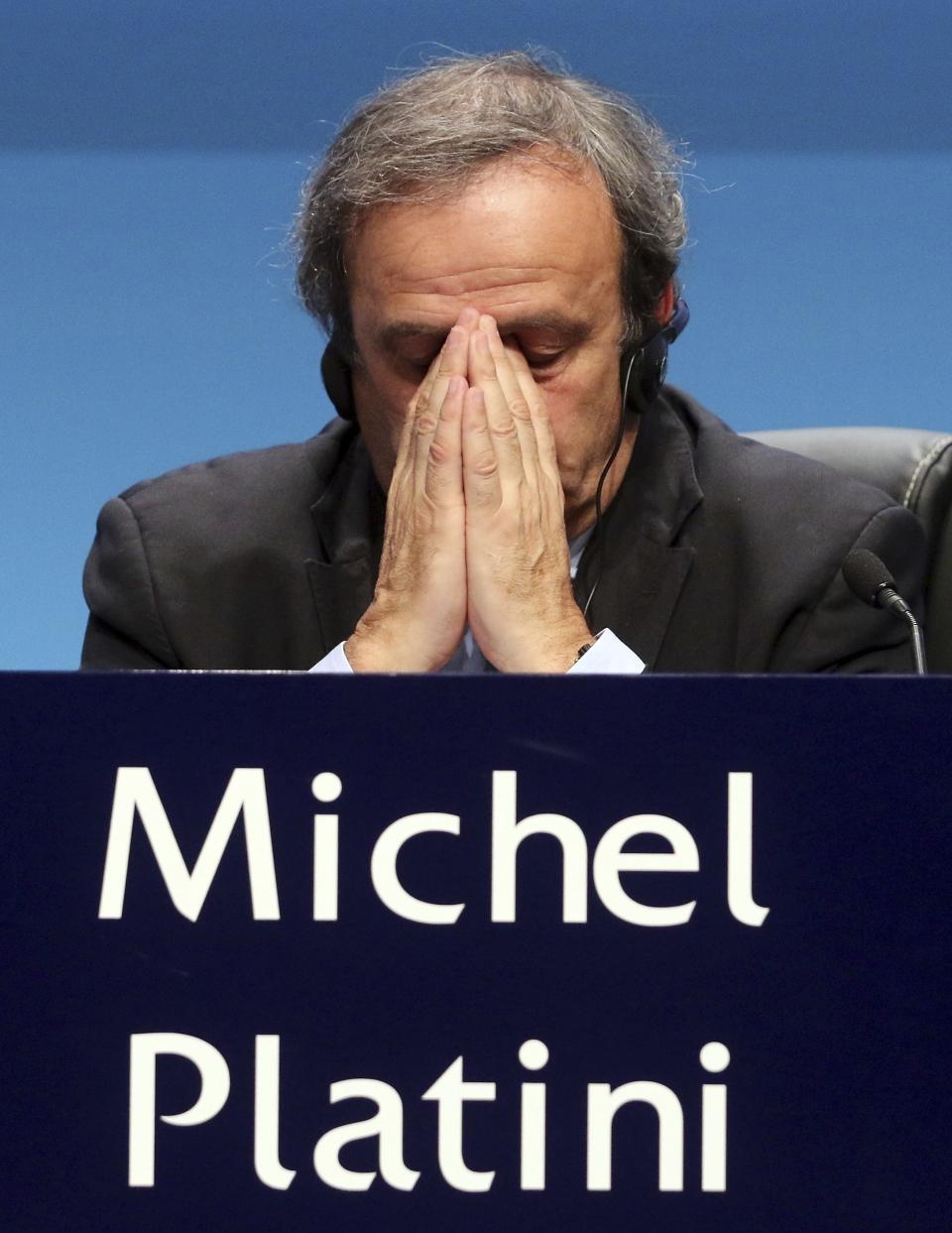 FILE - In this Tuesday, March 24, 2015 file photo UEFA President Michel Platini covers his face during a news conference at the end of the 39th Ordinary UEFA Congress in Vienna, Austria. Former UEFA president Michel Platini has been arrested Tuesday June 18, 2019 over the awarding of the 2022 World Cup. (AP Photo/Ronald Zak, File)