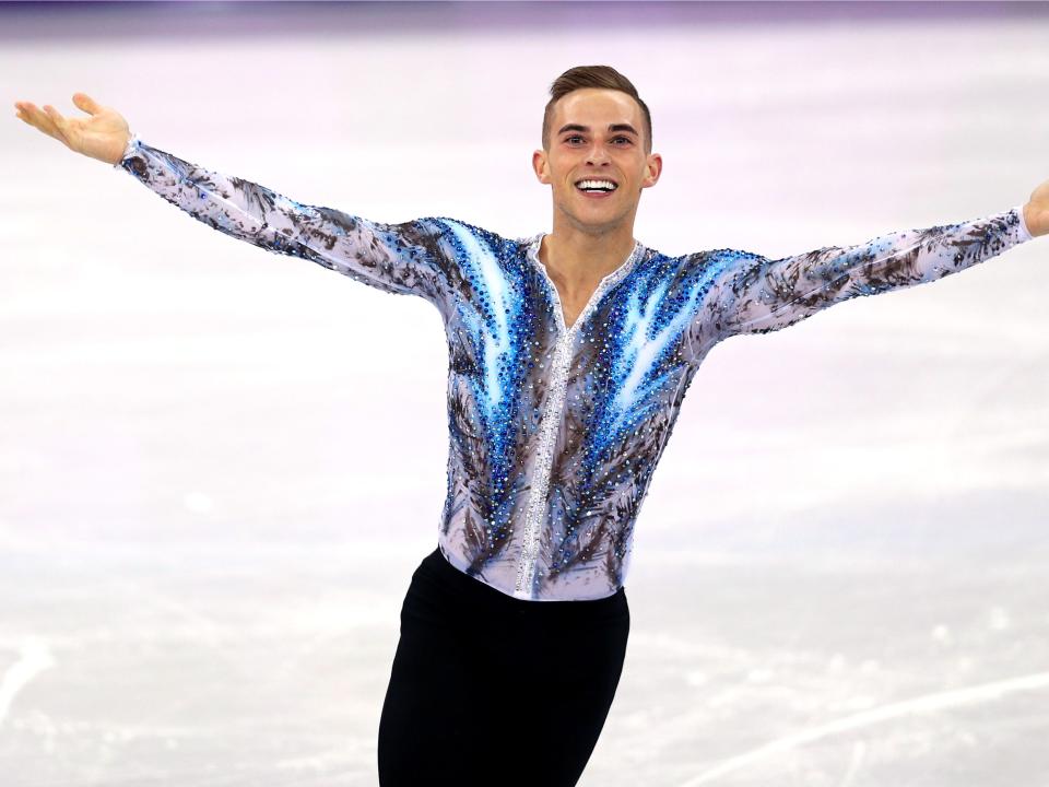 adam rippon olympic skater on the ice with arms outstretched in body suit