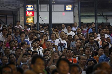 Spectators follow a fight from a stand that is known for gambling during the closing Thai boxing, or "Muay Thai", fight night of the legendary Lumpinee stadium, one of Bangkok's oldest boxing venues which is being demolished after 57 years, February 7, 2014. REUTERS/Damir Sagolj