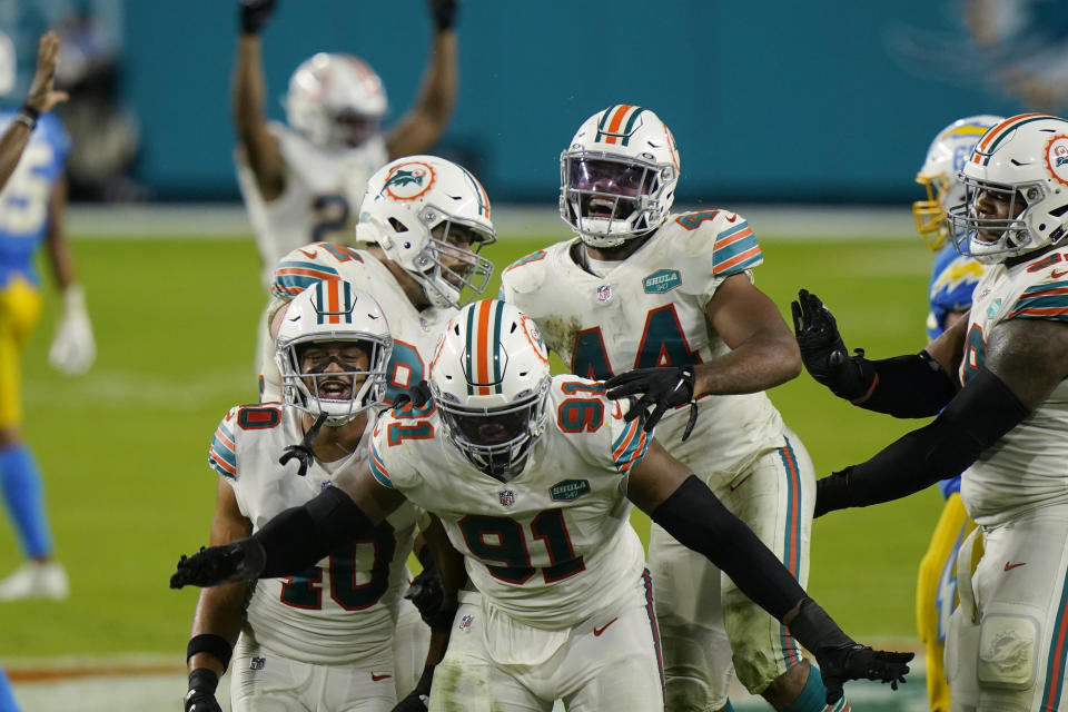 Miami Dolphins defensive end Emmanuel Ogbah (91) and his teammates celebrate after a play during the second half of an NFL football game against the Los Angeles Chargers, Sunday, Nov. 15, 2020, in Miami Gardens, Fla. (AP Photo/Lynne Sladky)