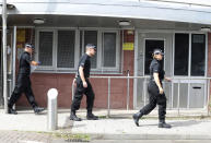 Police officers outside Brinklow Tower in Birmingham, England, where searches are being carried out in relation to the suspected terror attack on the Houses of Parliament in London, Wednesday Aug. 15, 2018. This search is believed to be linked to a car that crashed into security barriers outside the Houses of Parliament in London on Tuesday, and the driver was taken into custody. (Aaron Chown/PA via AP)