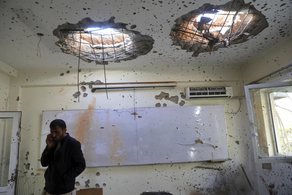A man talks on his phone inside a damaged room at the Kabul University following a deadly attack in Kabul, Afghanistan, Tuesday, Nov. 3, 2020. The brazen attack by gunmen who stormed the university has left many dead and wounded in the Afghan capital. The assault sparked an hours-long gun battle. (AP Photo/Rahmat Gul)