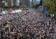 Demonstrators wave national flags of South Korea and the U.S. during a rally in Seoul, South Korea, Wednesday, Oct. 9, 2019. Thousands of protesters rallied Wednesday in South Korea's capital for the second consecutive week to call for the ouster of President Moon Jae-in's hand-picked justice minister, whose family is at the center of an investigation into allegations of financial crimes and academic favors. (AP Photo/Lee Jin-man)