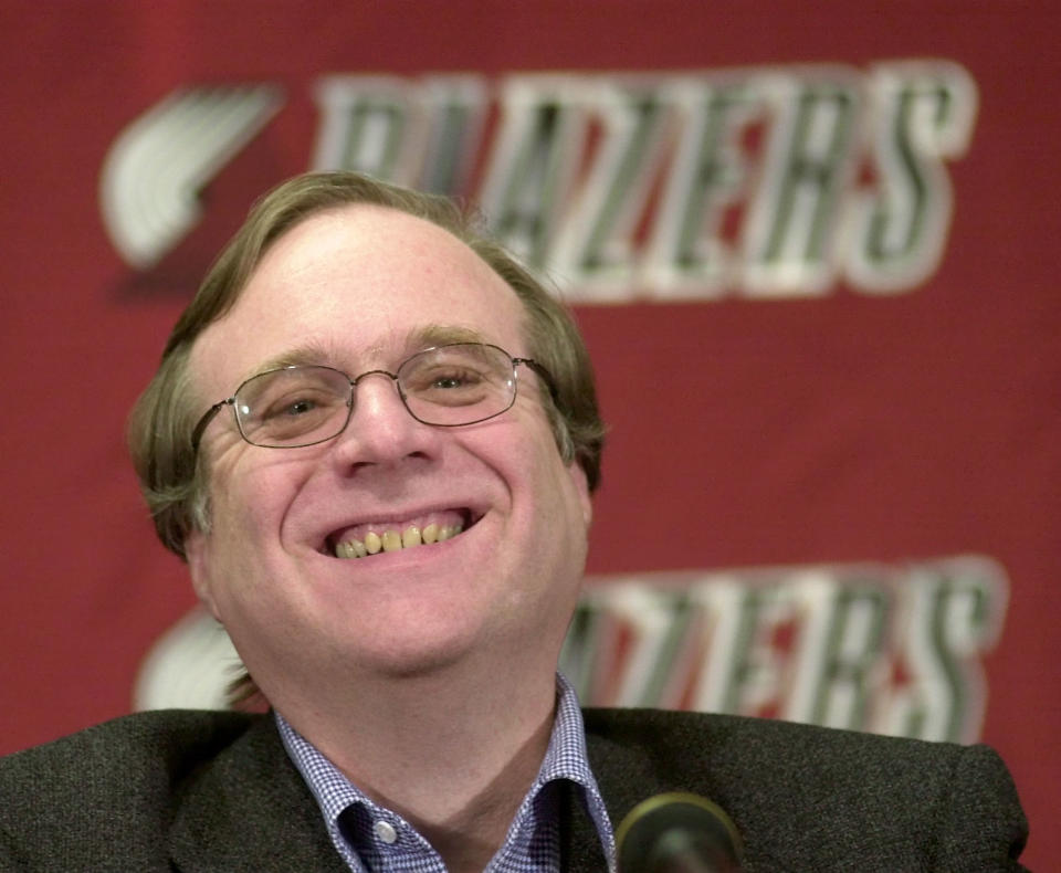 FILE - In this Feb. 10, 2004, file photo, Portland Trail Blazers owner Paul Allen smiles as he talks to the media at the Rose Garden arena during halftime of the Blazers game against the Utah Jazz in Portland, Ore. Allen, billionaire owner of the Portland Trail Blazers and the Seattle Seahawks and Microsoft co-founder, died Monday, Oct. 15, 2018 at age 65. Earlier this month Allen said the cancer he was treated for in 2009, non-Hodgkin's lymphoma, had returned. (AP Photo/Don Ryan, file)