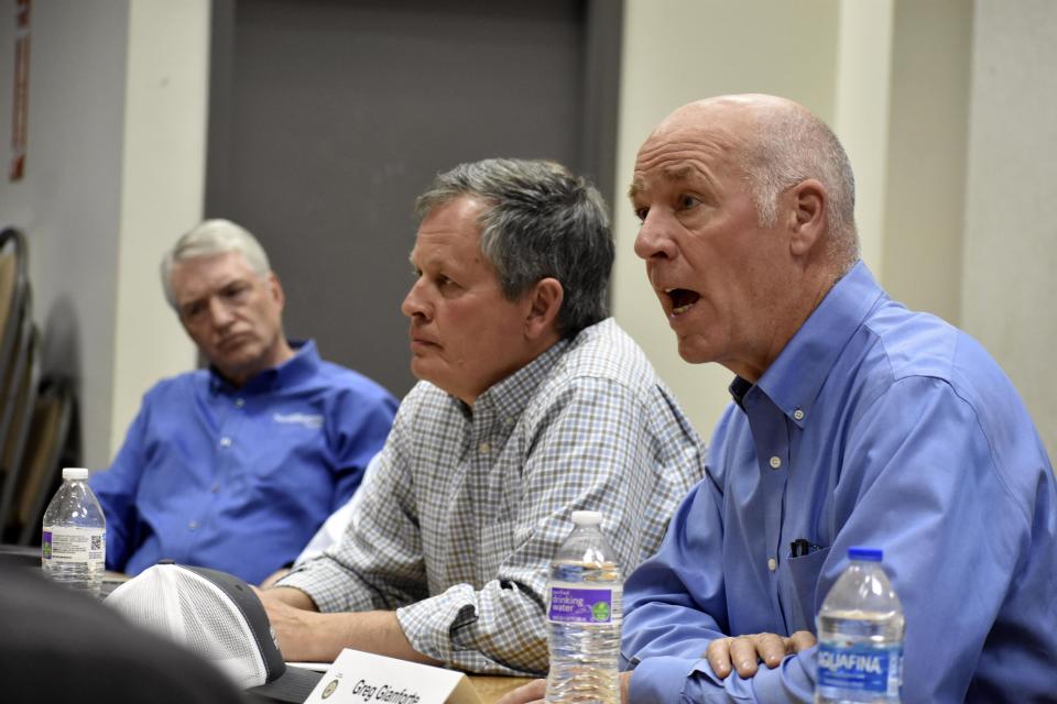 Montana Republican Gov. Greg Gianforte, right, talks about Biden administration policies impacting the coal industry as Republican Sen. Steve Daines, center, and NorthWestern Energy President Brian Bird look on during a roundtable meeting with coal executives and local officials at the Rosebud mine, on Tuesday, May 28, 2024, in Colstrip, Mont. Gianforte said electricity prices could go up because of the Democratic administration's policies. (AP Photo/Matthew Brown)