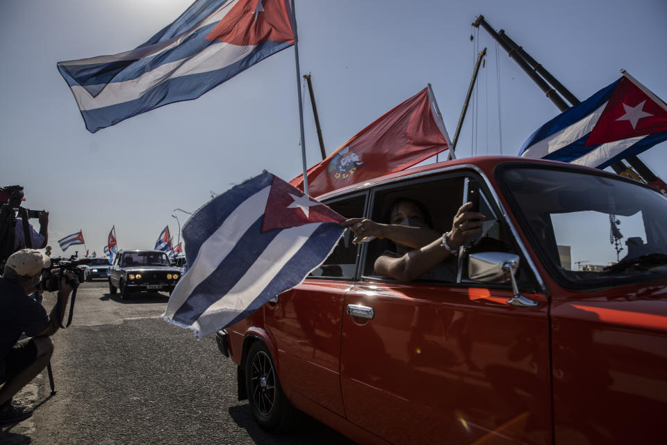 Autos Lada de la era soviética con bandera cubana pasan frente a la embajada estadounidense durante una manifestación que pide el fin del bloqueo estadounidense contra la nación isleña en La Habana, Cuba, el domingo 28 de marzo de 2021. (AP Foto/Ramón Espinosa).