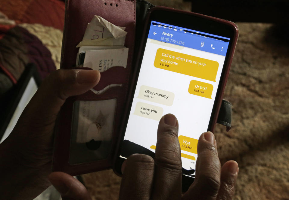 In this photo taken Tuesday, Aug. 6, 2019 Brenda Scurlock is shown in her home in Lumber Bridge, N.C. holding her phone showing the last texts she received from her son Avery just before he was murdered. Scurlock's son, who used the name Chanel when dressing as a woman in social settings and hoped to have sex reassignment surgery, was found shot to death in June. This death of a transgender person in North Carolina is one of 18 so far this year, and 17 of the victims have been black women. (AP Photo/Gerry Broome)