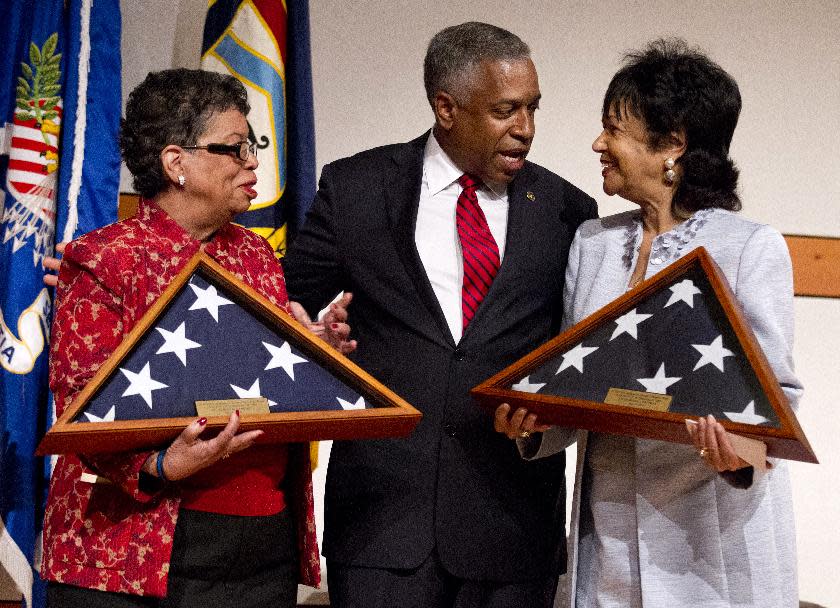 William Henderson Foote's great grand niece Bettye Gardner, left, and great grand daughter Patricia Nolcox, right, is presented with U.S. flags, flown over the Capitol, by Bureau of Alcohol, Tobacco, Firearms and Explosives (ATF) Acting Director B. Todd Jones during a memorial ceremony honoring the first African American post-reconstruction era federal law enforcement officer killed in the line of duty, Monday, May 14, 2012 in Washington. The name of William Henderson Foote, a deputy collector with an ATF legacy agency, the U.S. Department of the Treasury, Bureau of Internal Revenue (BIR), was unveiled on ATF's Memorial Wall during an event commemorating National Police Week. Foote was killed Dec. 29, 1883, in Yazoo City, Miss., almost 130 years ago. (AP Photo/Manuel Balce Ceneta)