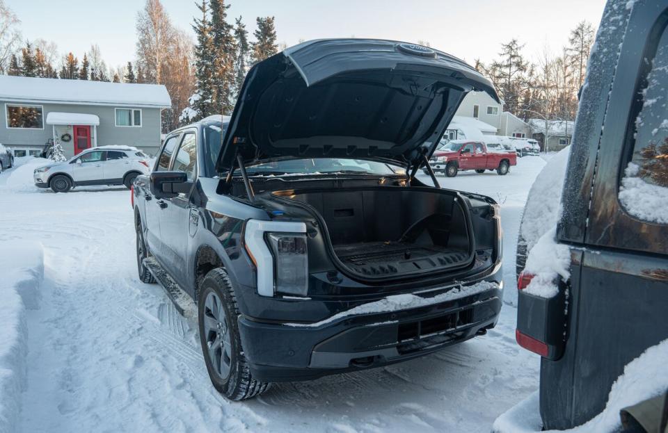 A fully electric truck, with its front hood open. The spot where an internal combustion engine would go is, in the electric Ford F150 Lightning, turned into storage space.