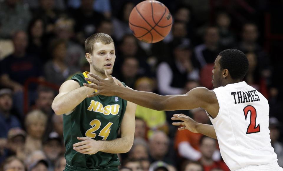 North Dakota State's Ryan Staten (24) passes as San Diego State's Xavier Thames defends in the first half during the third-round of the NCAA men's college basketball tournament in Spokane, Wash., Saturday, March 22, 2014. (AP Photo/Elaine Thompson)