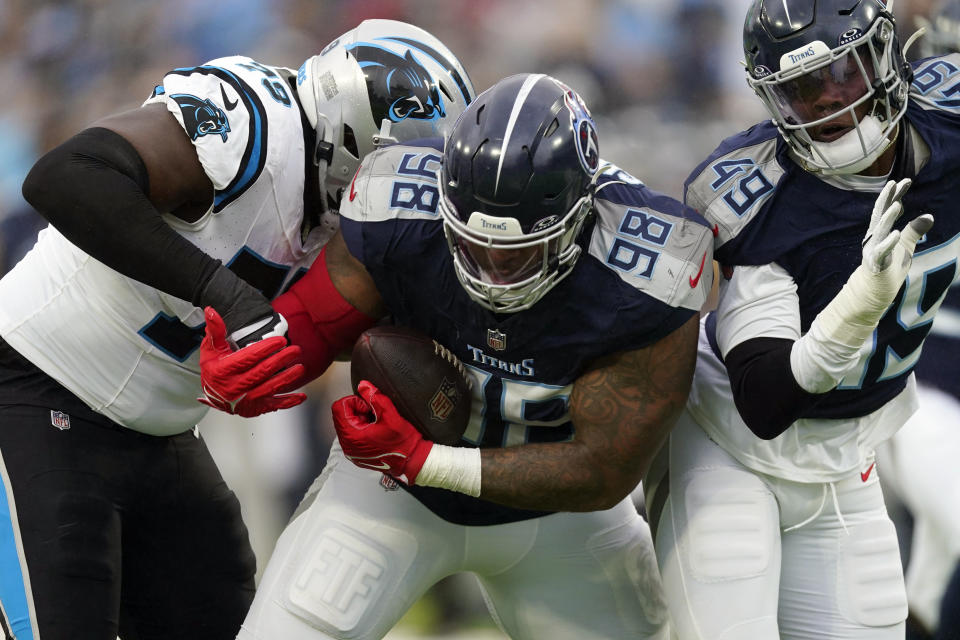 Tennessee Titans defensive tackle Jeffery Simmons (98) recovers a fumble ahead of Carolina Panthers offensive tackle Ikem Ekwonu, left, during the first half of an NFL football game Sunday, Nov. 26, 2023, in Nashville, Tenn. (AP Photo/George Walker IV)