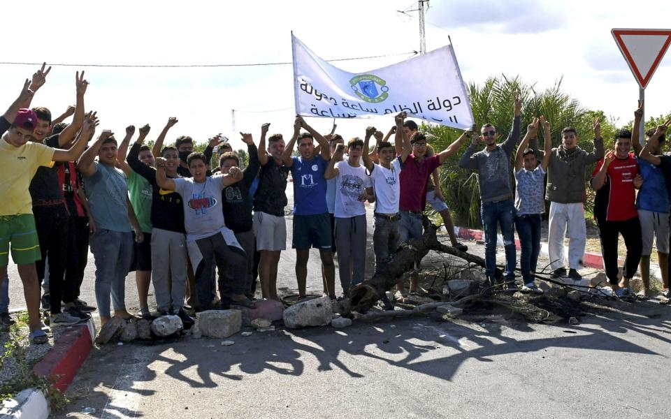 Tunisian youths prepare to burn tyres and block the road leading to Chebba to protest against the decision of the Tunisian Football Federation to freeze the activities of their team - AFP