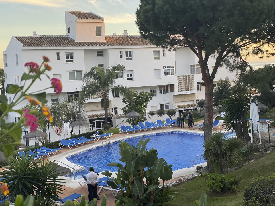 In this photo taken on Tuesday Dec. 24, 2019, Civil guard divers, right, work at the side of a swimming pool at the Club La Costa World holiday resort near Malaga, Spain. Spanish police are investigating the swimming pool deaths of a British man, his 9-year-old daughter and 16-year-old son in Spain's Costa del Sol. (AP Photo)