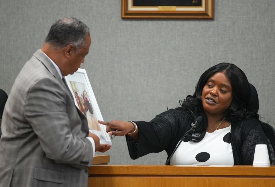 The sister of Javier Ambler, Kimberly Ambler Moore, points out her brother and her children in a family photograph to prosecutor, Dexter Gilford, at the Blackwell-Thurman Criminal Justice Center on Monday, February 26, 2024.