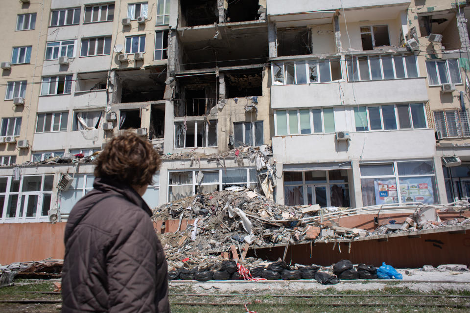 ODESSA, UKRAINE - APRIL 25: A resident whose apartment got destroyed as a result of a missile strike on a residential building, looks at the work of the rescue team on April 25, 2022 in Odessa, Ukraine. Ukrainian forces, as well as civilian Odessans, remain on guard against a potential Russian advance on this historic port city, whose capture could help give Russia control of Ukraine's southern coast. But given Russia's setbacks in this two-month-long war, including the sinking of its Black Sea Fleet's flagship Moskva, analysts regard a full-scale attack on Odessa to be unlikely. (Photo by Anastasia Vlasova/Getty Images)