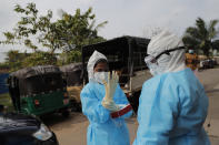 Sri Lankan health officials prepare to collect swab samples to test for COVID-19 in Colombo, Sri Lanka, Monday, Nov. 23, 2020. (AP Photo/Eranga Jayawardena)