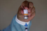 A healthcare worker prepares a dose of the China's Sinovac CoronaVac vaccine during a priority vaccination program for the elderly at Bezerra de Menezes Asylum in Brasilia, Brazil, Thursday, Feb. 18, 2021. (AP Photo/Eraldo Peres)