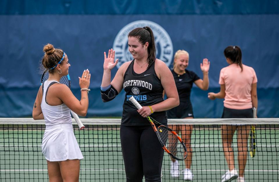 Iryna Trystan, 21, a Ukraine student from Northwood University, celebrates with her teammate after performing a challenging play during the first tennis practice of the season at the Gerstacker Tennis Center in Midland on Thursday, Aug. 25, 2022. 