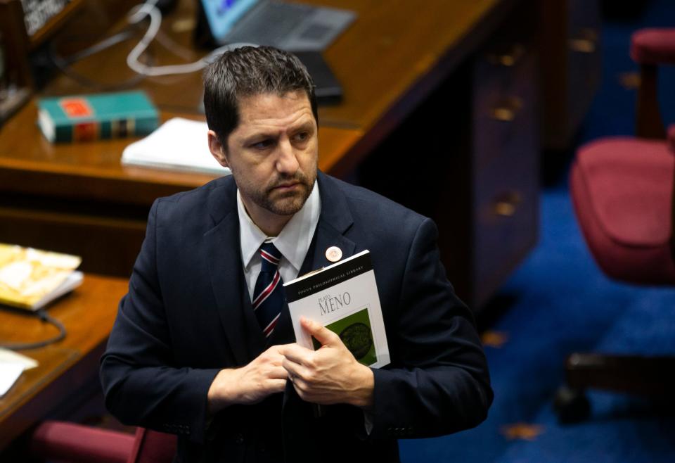 Republican state Sen. Paul Boyer, LD-20, holds the book "Meno" by ancient Greek philosopher Plato as the Senate votes on bills related to the budget on the Senate floor at the Arizona Capitol in Phoenix on June 22, 2021.