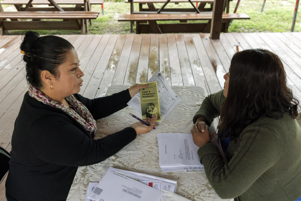 Children's Defense Fund program director Graciela Camarena assists Lucia Salazar with filling out Medicaid and SNAP application forms for her family in Pharr, Texas, Monday, Nov. 13, 2023. As the state reviews Texans' eligibility, some 1 million people have already lost Medicaid and organizations like the one Graciela works for assist people in applying again. (AP Photo/Michael Gonzalez)