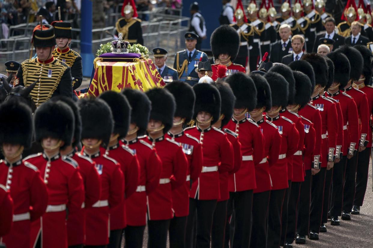 The coffin of Queen Elizabeth, draped in the Royal Standard with the Imperial State Crown placed on top, is carried on a horse-drawn gun carriage of the King's Troop Royal Horse Artillery, during a procession from Buckingham Palace to Westminster Hall on Sept. 14, 2022. (Aaron Chown/Pool via AP)