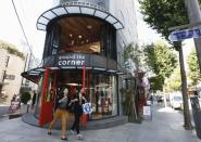 Women smile as they walk out of a shop on the Garosugil or the Tree-Lined Street in the Gangnam area of Seoul.