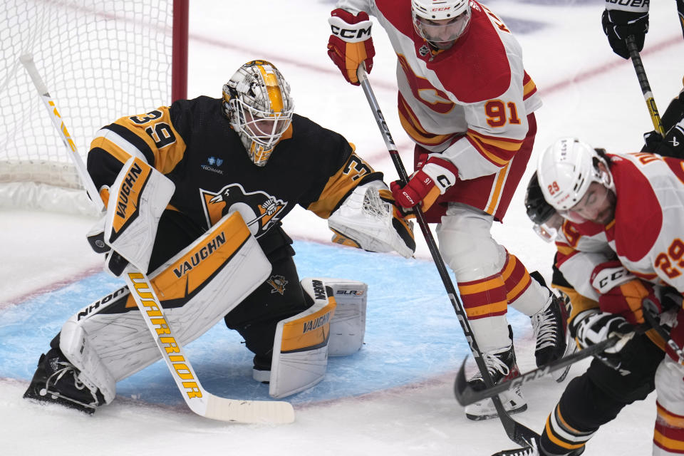 Pittsburgh Penguins goaltender Alex Nedeljkovic (39) watches as Calgary Flames' Nazem Kadri (91) looks for a rebound during the first period of an NHL hockey game in Pittsburgh, Saturday, Oct. 14, 2023. (AP Photo/Gene J. Puskar)