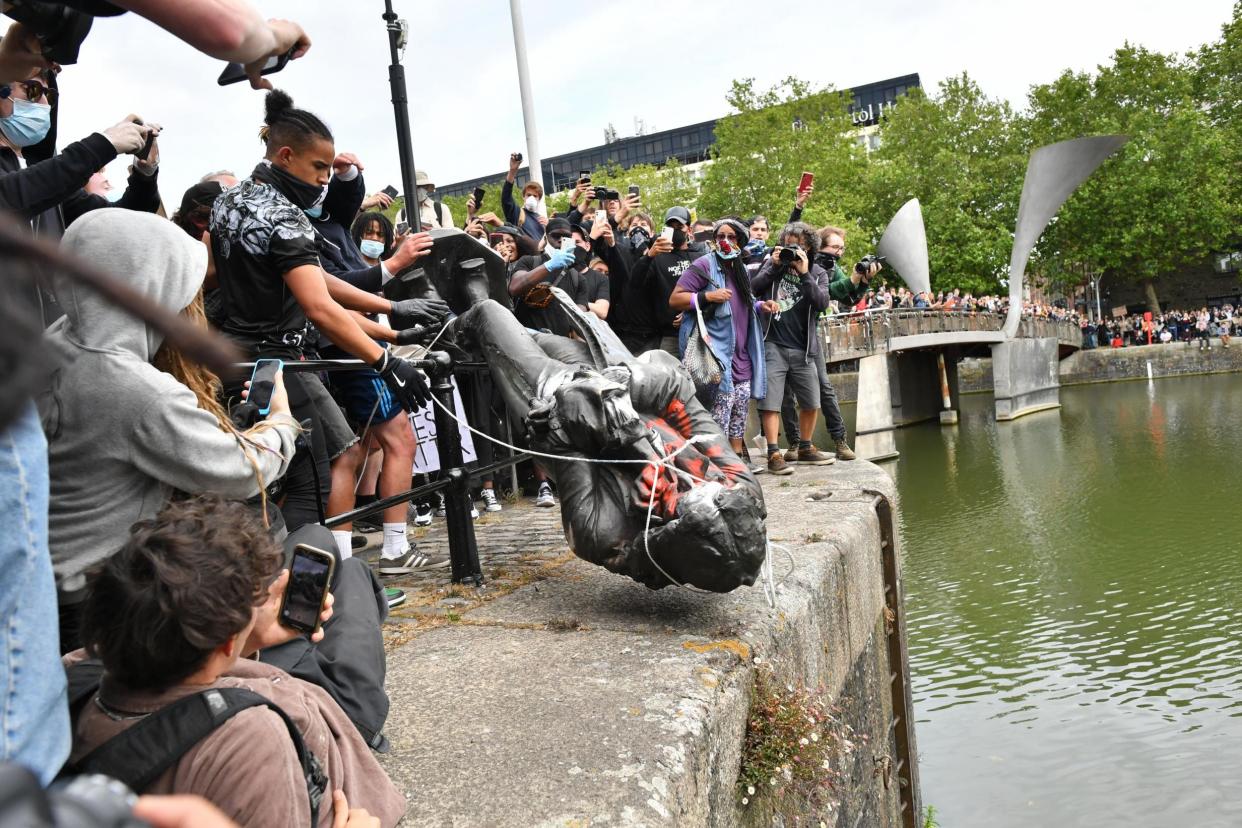 Protesters throw the statue of Edward Colston into Bristol harbour (PA)